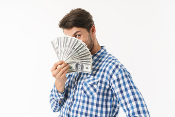 Bearded unshaved man dressed in casual shirt posing isolated over white wall background holding money covering face.