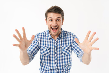 Photo of happy delighted man in casual shirt wondering and smiling at camera with throwing up arms