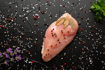 Raw chicken breast fillets on wooden cutting board with herbs and spices. top view with copy space