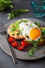 breakfast avocado sandwich with fried egg and tomato