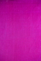 Close up of a pink colored vertical shot of the fabric texture with some minimal square pattern on it.