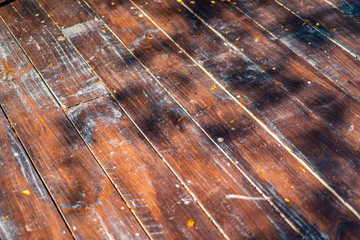 Damaged outdoor wood plate arrange and transform to the floor with the shadow of tree.