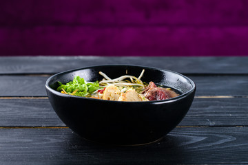 Spicy Asian beef soup with noodles and chinese vegetables