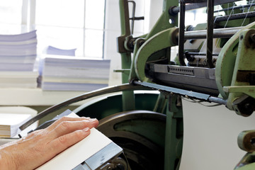 Machine for stitching book pages with threads in typography.