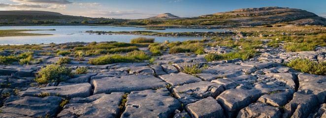 Fototapeta na wymiar A panorama of the stunning and mars like landscape that is The Burren National Park, County Clare, Ireland at dusk.