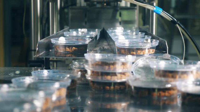 Plastic containers with dried breads stacked on a metal tray.