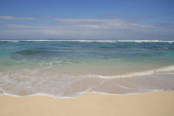 Fototapeta na wymiar View from a beautiful white sandy beach on the ocean horizon and blue sky 