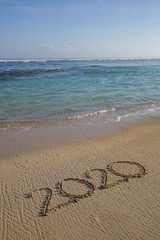 2020 written on the empty sandy beach