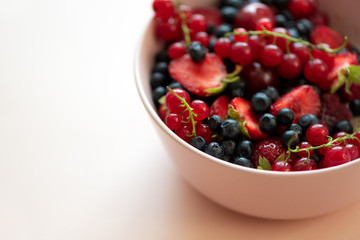 Porridge bowl oatmeal with berries on pink background. Soft focus. Healthy eating concept. Front view