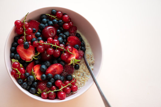 Porridge Bowl Oatmeal With Berries On Pink Background. Soft Focus. Healthy Eating Concept. Front View