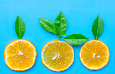 Summer of slice orange fruit with green Leaves on blue background.