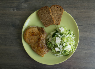 Pork on the bone, coleslaw, cheese and pickled cucumbers, whole grain bread