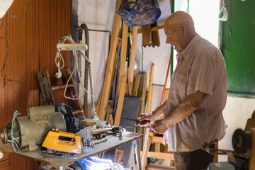 Elderly man sharpening a knife with a lime