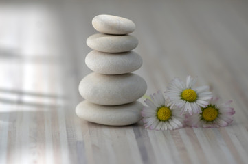 Fototapeta na wymiar Harmony and balance, cairns, simple poise pebbles on wooden light white gray background, simplicity rock zen sculpture