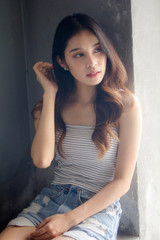 Fototapeta premium Portrait of thai adult beautiful girl White shirt blue jeans relax time