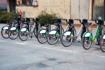 Green city bikes for rent in urban bicycle rental station