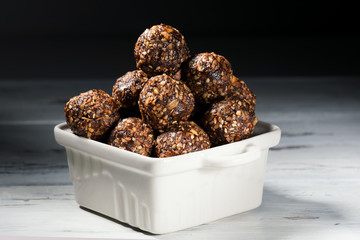 Raw homemade paleo energy balls with rolled oats, nuts, dates and sesame, horizontal, close up
