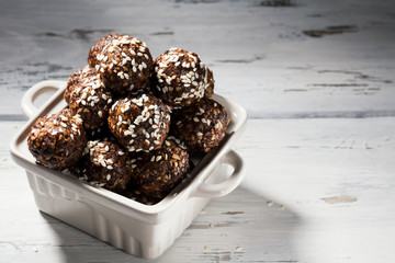 Raw vegan homemade paleo energy balls with rolled oats, nuts, dates and sesame, horizontal, copy space
