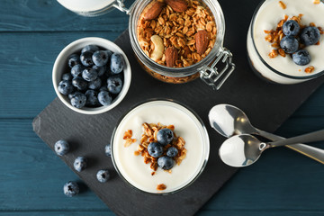 Composition with parfaits desserts on blue wooden background