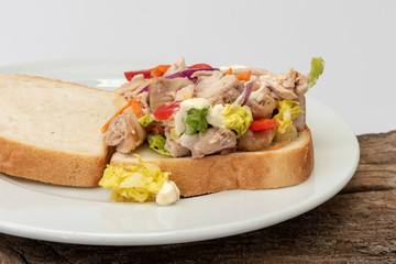 Sándwich de pollo con verduras y mayonesa.