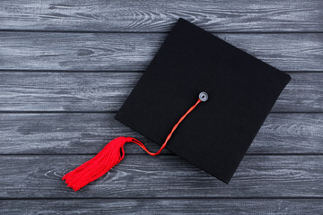 Graduation cap on black wooden table