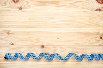 Blue measuring tape on brown wooden table