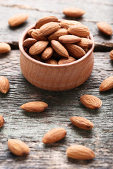 Almonds in bowl on grey wooden table