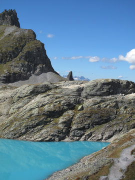 turquoise glacier lake 5-Lakes HiThe mountain landscape and cloudy sky are reflected in the deep blue turquoise of the water. The melt water colours the wild sea turquoise. In the trianke, Wildsee, CH
