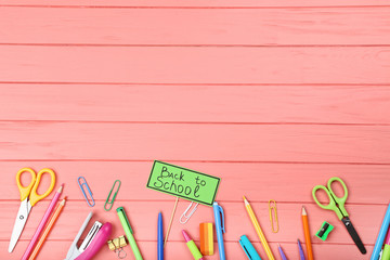 Text Back To School with stationery on wooden table