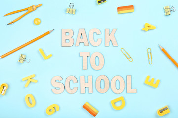 Text Back To School with stationery on blue background