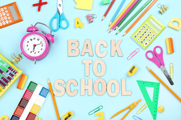 Text Back To School with stationery on blue background