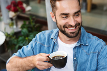 Handsome smiling man sitting at the cafe table