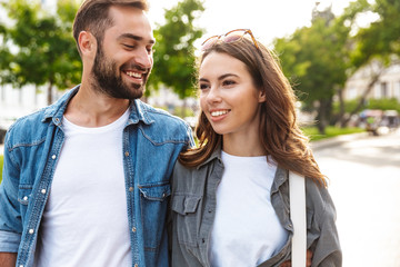 Naklejka premium Beautiful young couple in love walking outdoors at the city street