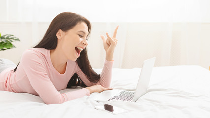 Young millennial girl using digital tablet in bed