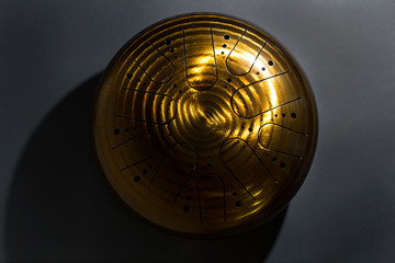 Golden hang drum on a black background, near view, centered object