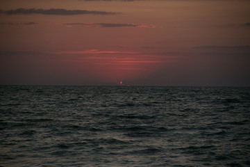 Fototapeta premium The setting sun going beyond the horizon of the Azov sea