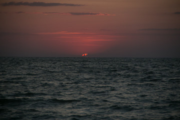 Naklejka na ściany i meble The setting sun going beyond the horizon of the Azov sea
