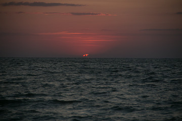 Fototapeta premium The setting sun going beyond the horizon of the Azov sea