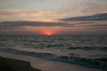 Fototapeta na wymiar The setting sun going beyond the horizon of the Azov sea