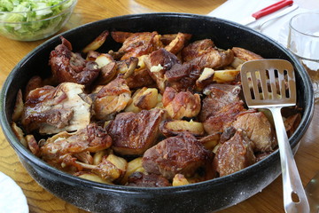 Dish with stew and potatoes cooked on the grill