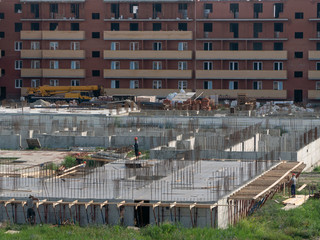The work of the brigade in the construction of a monolithic multistory residential building. Panoramic view of the foundation and the lowest level