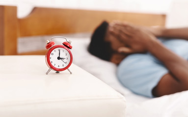 Black man in bed suffering from insomnia and sleep disorder