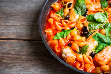 Fresh pasta with sausages, olives and basil leaves. Selective focus. Shallow depth of field.