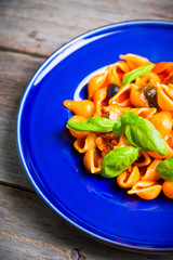 Fresh pasta with sausages, olives and basil leaves. Selective focus. Shallow depth of field.
