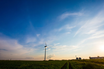 Wind industry in rural area. Turbines in farmlands in evening. Beautiful landscape