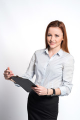 Happy smiling woman in strict clothes and glasses holding a clipboard on grey