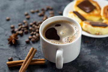 A Cup of fragrant espresso coffee and cheesecakes with chocolate and cinnamon