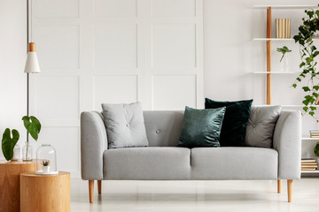 Designed gray couch with wooden legs in modern interior