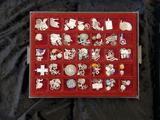 Old wooden drawer lined with red velvet, with many compartments, filled with old  jewelry pendants