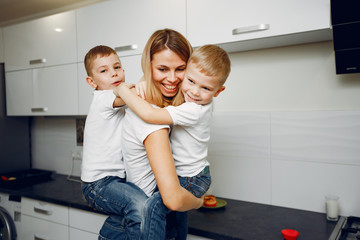 Family in a room. Little boy in a white t-shirt. Mother with son